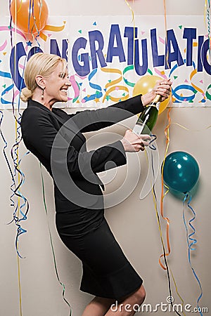 Businesswoman opening bottle of champagne Stock Photo