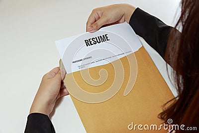 Businesswoman opening resume in letter envelope Stock Photo