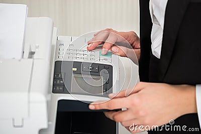 Businesswoman Operating Printer In Office Stock Photo