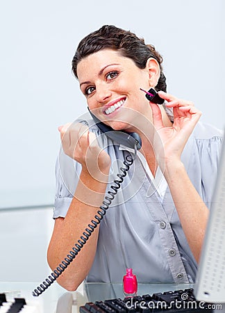 Businesswoman painting her nails while calling Stock Photo