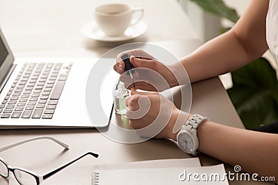 Businesswoman painting nails at office Stock Photo