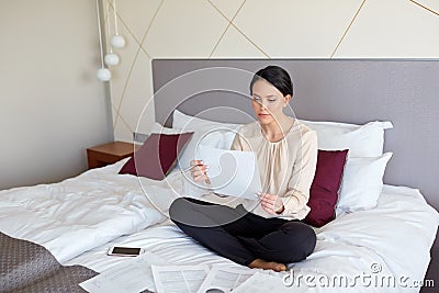 Businesswoman with papers working at hotel room Stock Photo