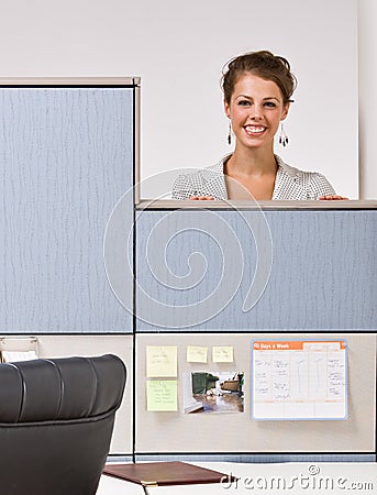 Businesswoman peering over cubicle wall Stock Photo