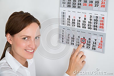 Businesswoman Placing Red Mark On Calendar Date Stock Photo