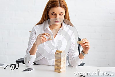 Businesswoman playing blocks wood game at Stock Photo
