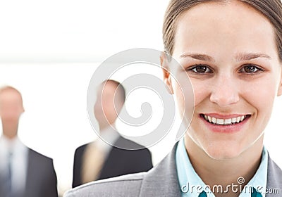 Businesswoman posing in front of two businessmen Stock Photo