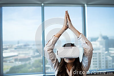 Businesswoman practicing yoga while using virtual reality glasses Stock Photo