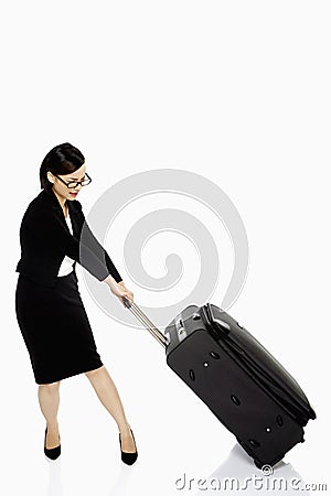 Businesswoman pulling a heavy luggage bag Stock Photo