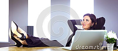 Businesswoman relaxing at her desk Stock Photo