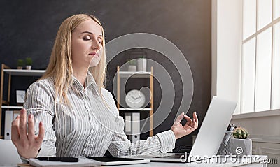 Businesswoman relaxing and meditating at workplace Stock Photo
