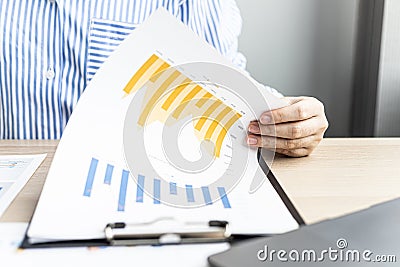 A businesswoman is reviewing the sales summary sheet from the sales department. Stock Photo
