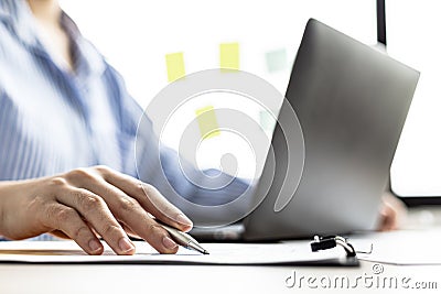 A businesswoman is reviewing the sales summary sheet from the sales department. Stock Photo