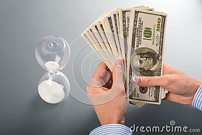 Businesswoman's cash and hourglass. Stock Photo