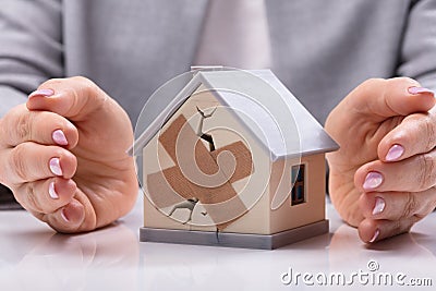 Businesswoman Protecting Broken House Stock Photo