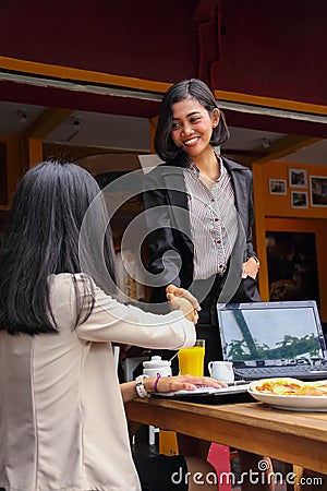 Businesswoman is shaking hands as she meets up with her business acquaintance Stock Photo