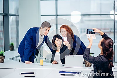 Businesswoman shooting her collegues at mobile phone camera Stock Photo