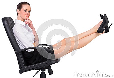 Businesswoman sitting on swivel chair with feet up Stock Photo