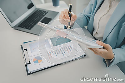 Businesswoman is sitting and working in the office, Employee is looking for information on laptop, Recording various information Stock Photo