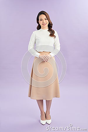 Businesswoman standing with folded hands. Smilng woman on purple wall background Stock Photo