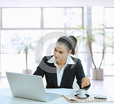 Businesswoman stirring coffee Stock Photo