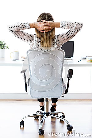 Businesswoman stretching relaxing on moment in her office. Satisfied with work done concept. Stock Photo