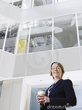 Businesswoman With Takeaway Coffee Cup In Office Stock Photo