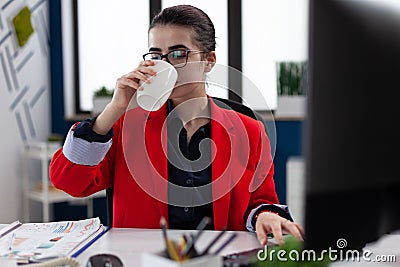 Businesswoman taking a sip of coffe working in corporate office Stock Photo