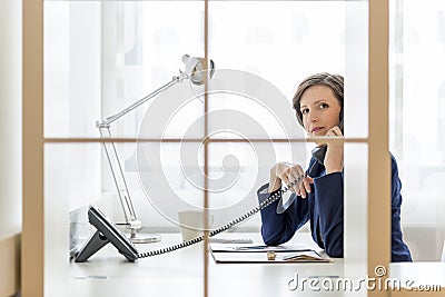 Businesswoman talking on a phone in the office Stock Photo