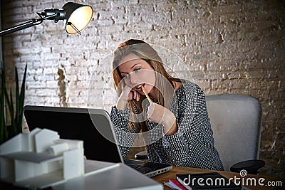 Businesswoman thinking with pencil in mouth Stock Photo