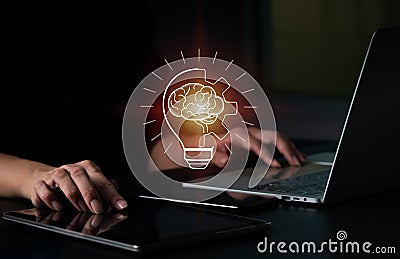 A businesswoman touches a digital tablet, and a bright light bulb appears on the screen. Ideas Concept for displaying fresh ideas Stock Photo