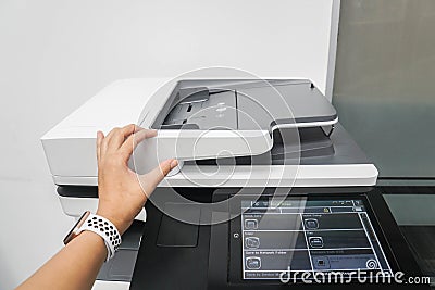 Businesswoman use multi function printer to scan documents in office Stock Photo