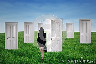 Businesswoman walks into opportunity doors Stock Photo