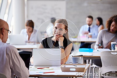 Businesswoman Wearing Smart Watch In Busy Office Stock Photo