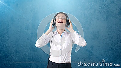 Businesswoman in white skirt relaxing listening to music on stereo headphones with blissful smile. Background isolated . Stock Photo