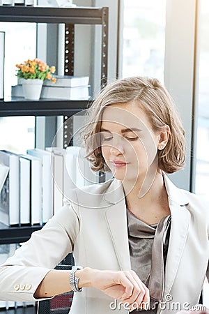 Businesswoman in white suit Watch wristwatch and serious about important Time for to late and delay Stock Photo