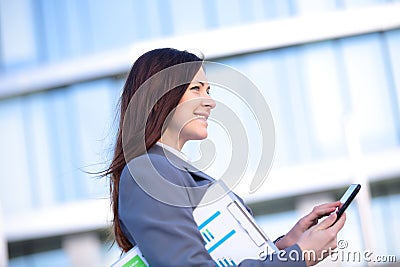 Businesswoman working on digital tablet outdoor over building background Stock Photo