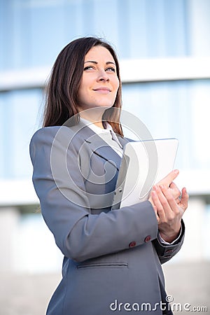 Businesswoman working on digital tablet outdoor over building background Stock Photo