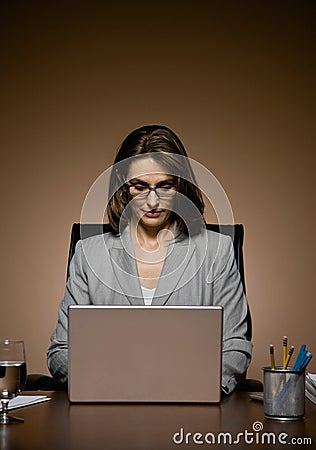 Businesswoman working late and typing on laptop Stock Photo