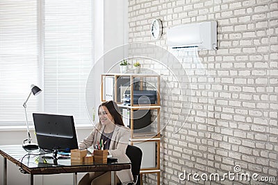 Businesswoman Working In Office With Air Conditioning Stock Photo