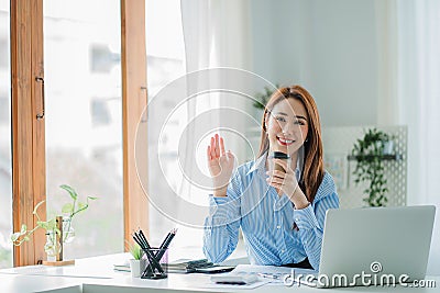 Businesswoman working in the office during coffee break smiling at the window giving a clear vision of work and success instilling Stock Photo