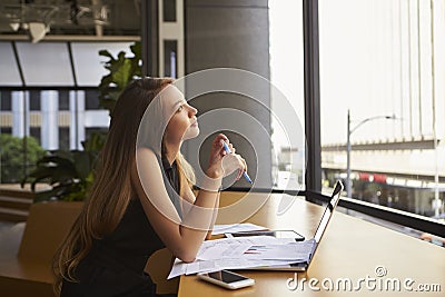 Businesswoman working in an office looking out of the window Stock Photo