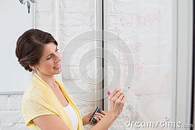 Businesswoman writing brainstorming ideas on board Stock Photo