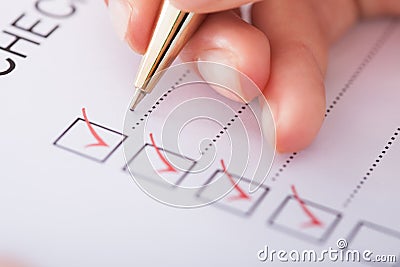 Businesswoman writing on checklist Stock Photo