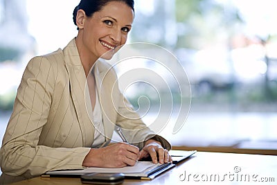 Businesswoman writing in her agenda Stock Photo