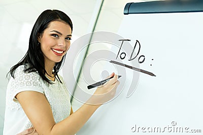 Businesswoman writing todo onto a white writing board Stock Photo