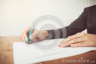 Businesswoman's hand with pen completing personal information Stock Photo