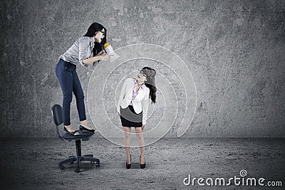 Businesswoman yelling to her employee Stock Photo