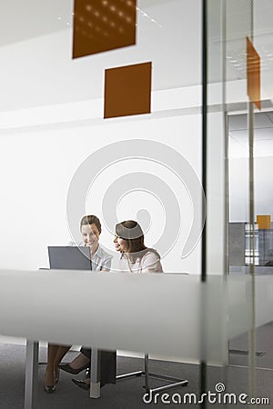 Businesswomen Discussing Over Laptop In Office Stock Photo