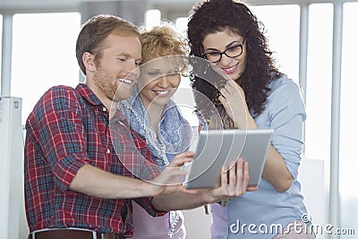 Businesswomen with male colleague using tablet PC in creative office Stock Photo