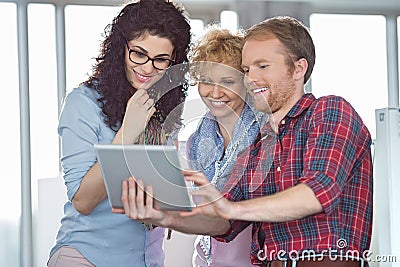 Businesswomen with male colleague using tablet PC in creative office Stock Photo